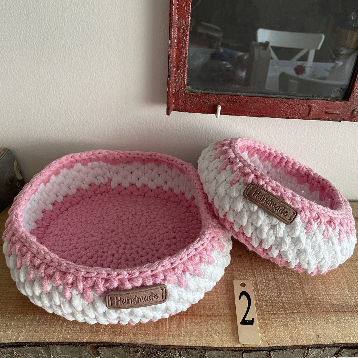 Hæklede kurve i lyserødt og hvidt med Handmade-mærkat