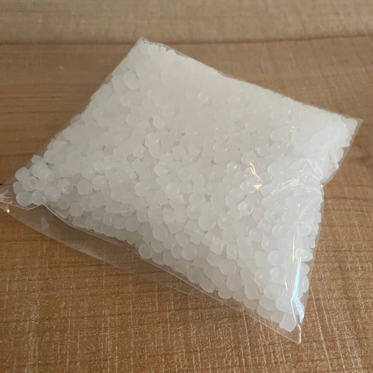 Pose med 50 gram hvidt plastgranulat til fyld, set skråt