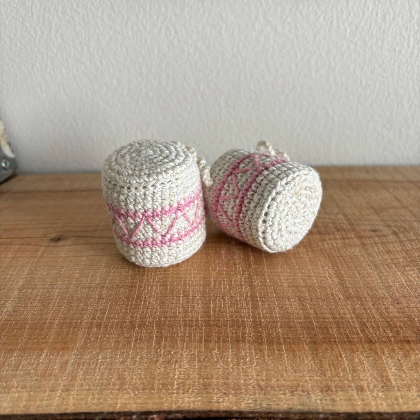 To hæklede trommer med pink mønster, liggende