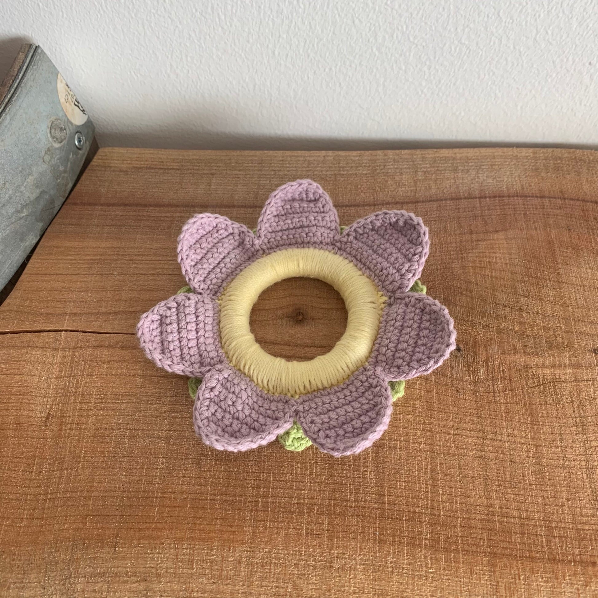 Ferskenfarvet blomsterbidering med raslekugle i midten
