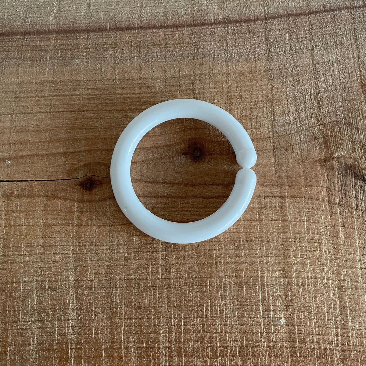 Hvid C-ring til baby, liggende på bord