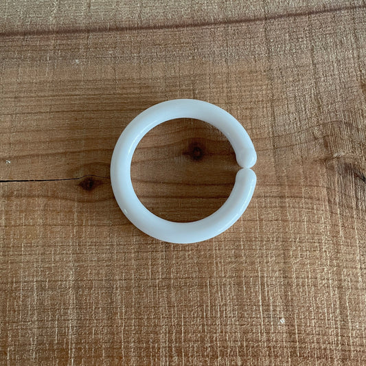 Hvid C-ring til baby, liggende på bord