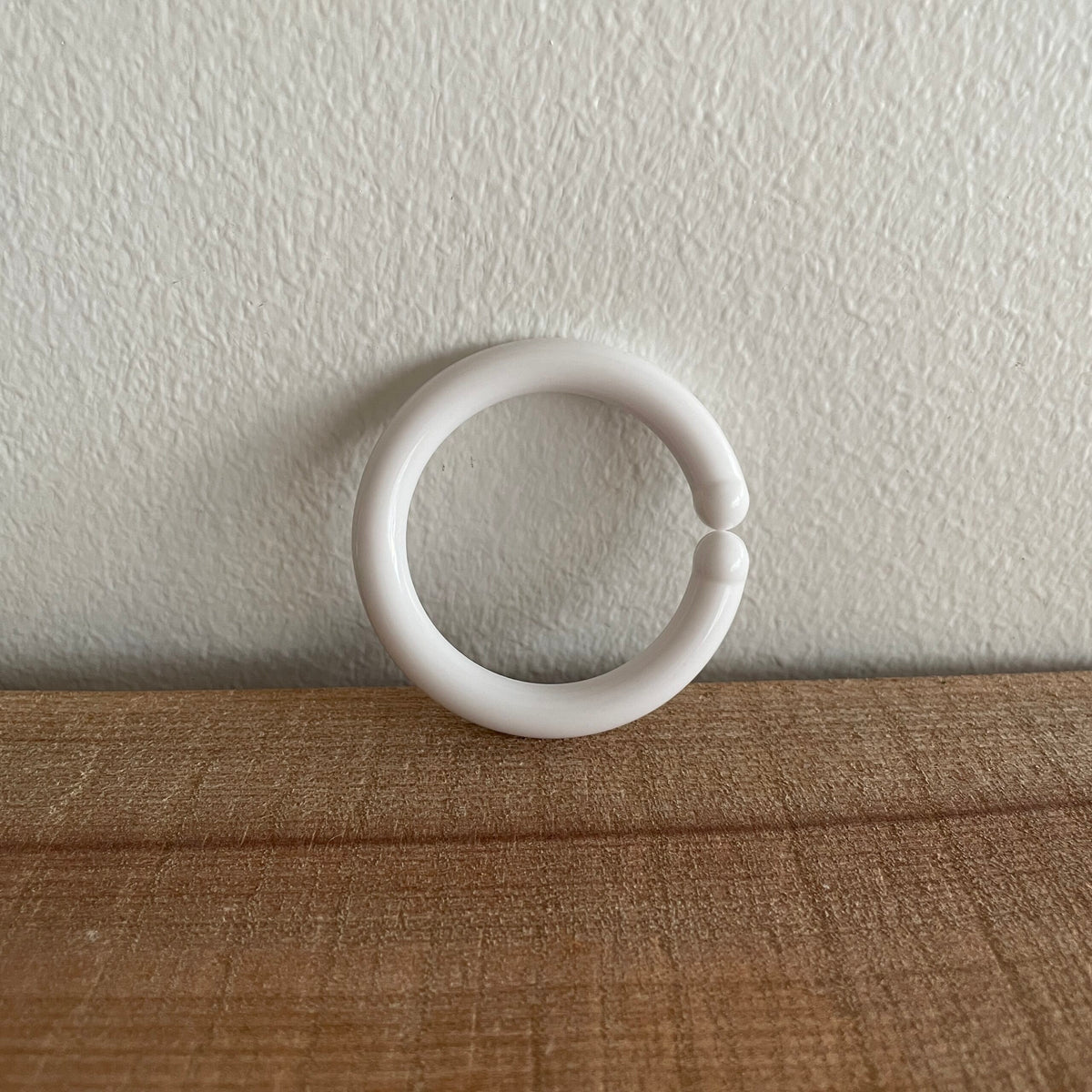 Hvid C-ring til baby, lænet op ad væg