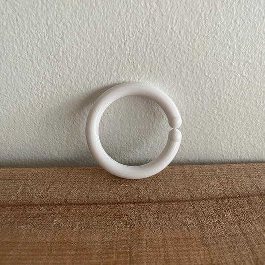 Hvid C-ring til baby, lænet op ad væg