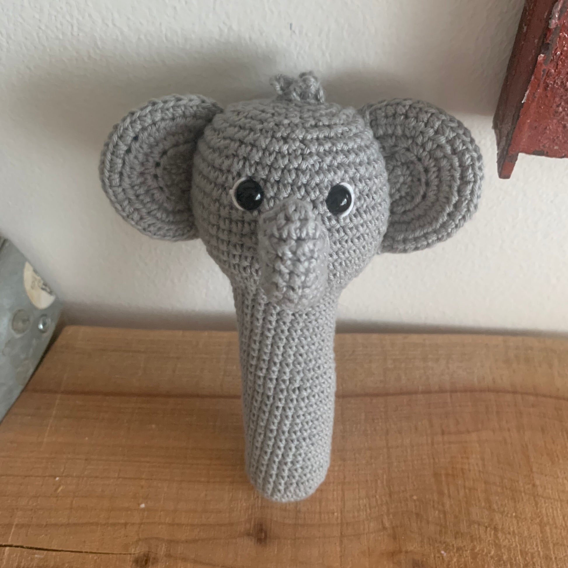 Hæklet elefant-rangle liggende ned, set fra siden