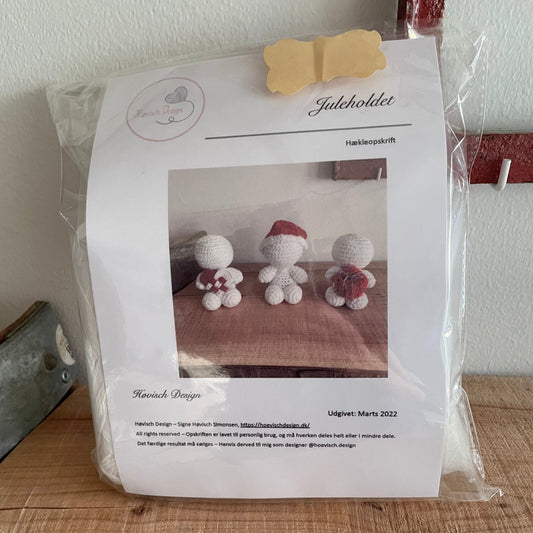 Forside af hækleopskrift til juleholdet fra Høvisch Design med tre hvide figurer