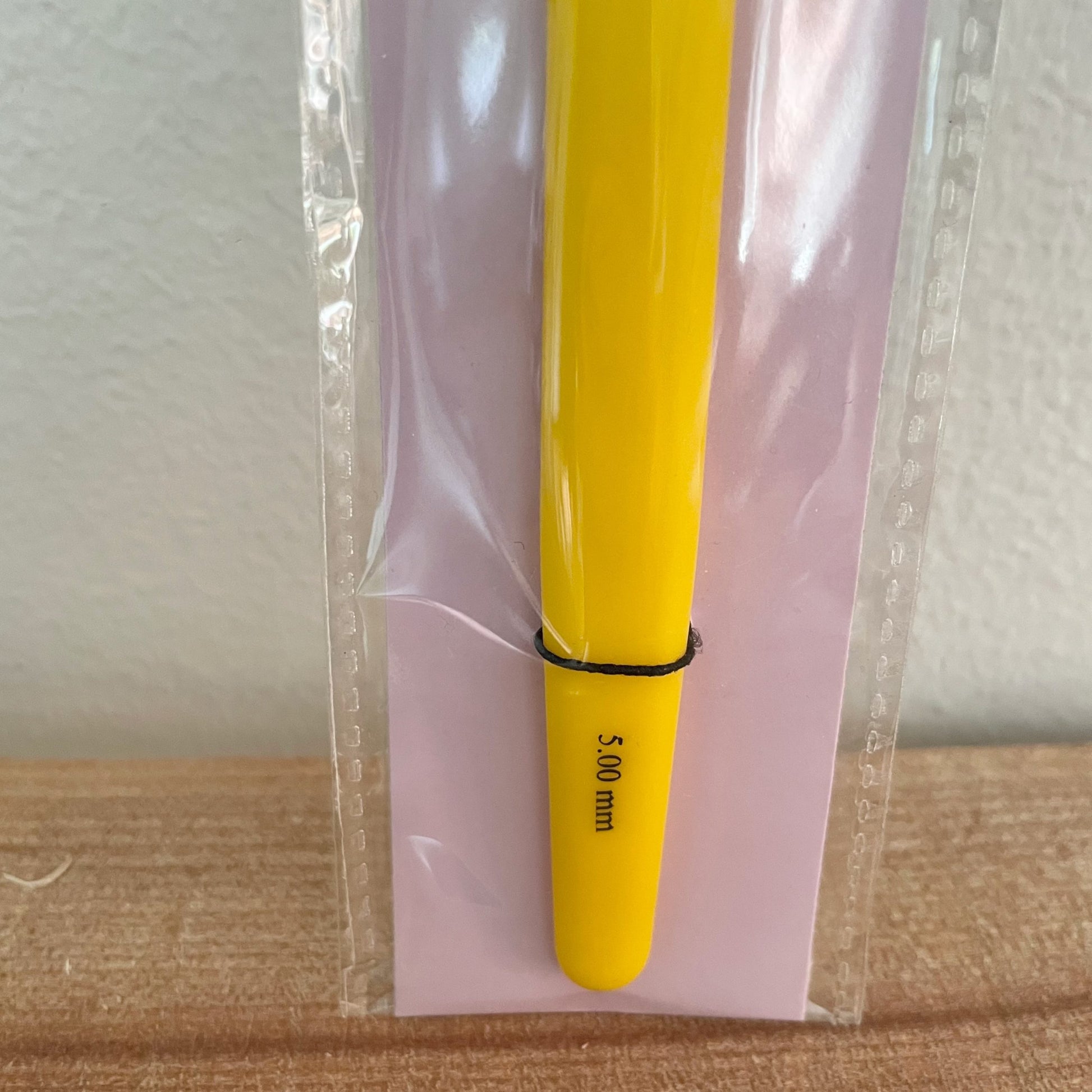 Nærbillede af hæklenål 5,00 mm med gult greb og mærkat