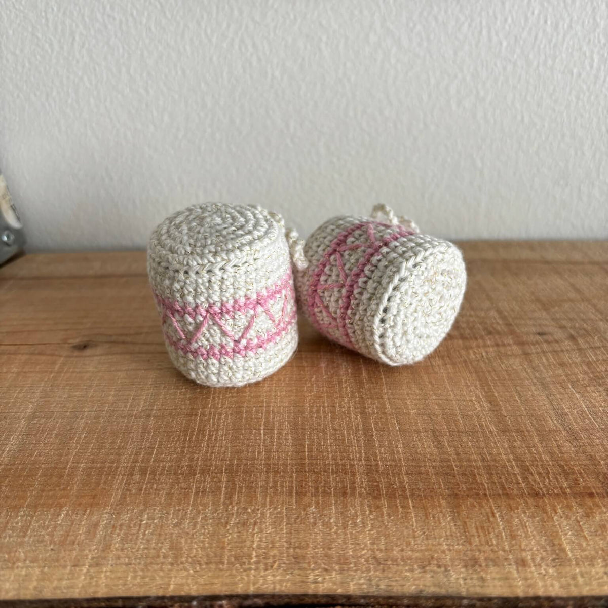 To hæklede trommer med pink mønster, liggende