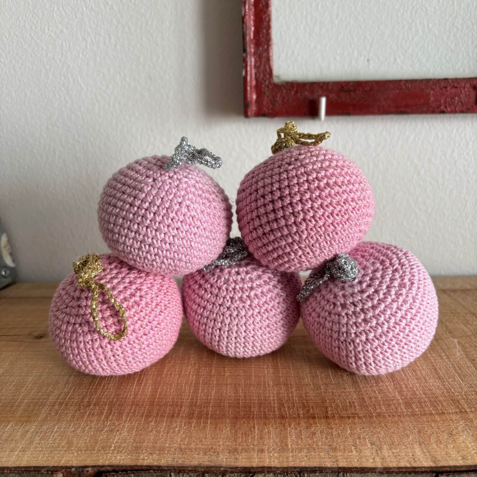 Fem hæklede julekugler i pink, samlet