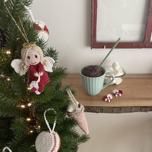 Hæklet Kayas Engel hængende på juletræ ved siden af julekugler