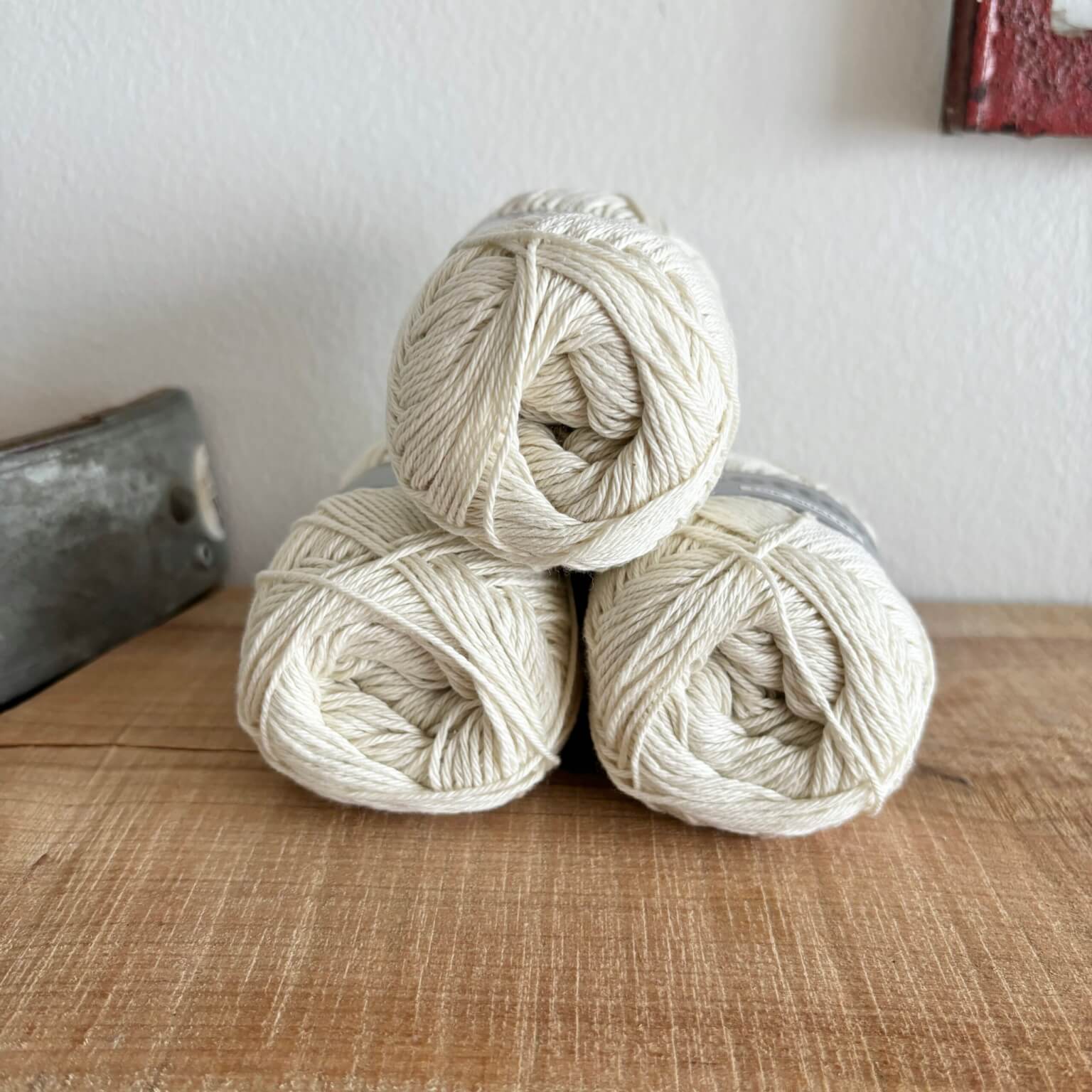 Tre garnnøgler Lammy Cotton 8/4 i creme, stablet