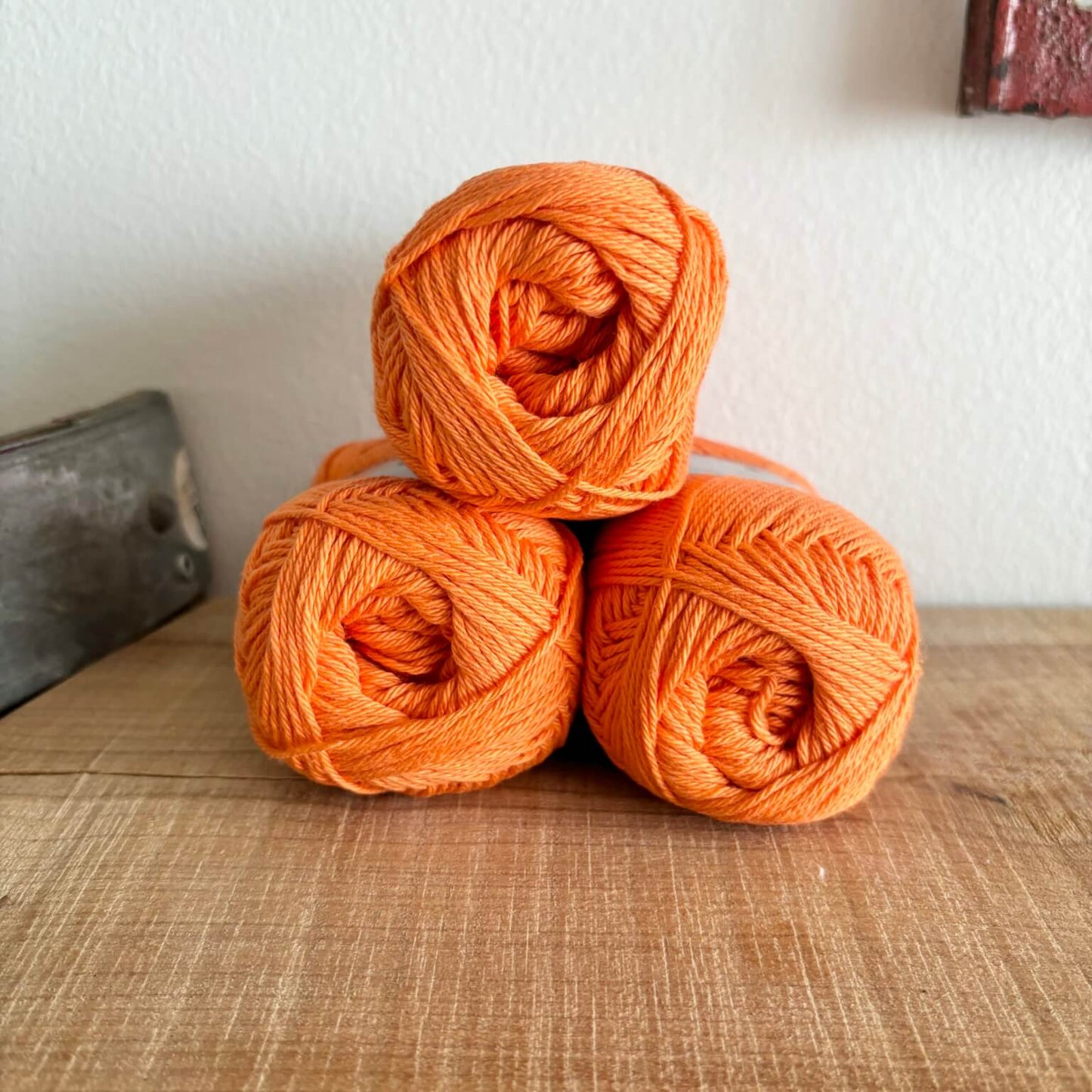 Tre garnnøgler Lammy Cotton 8/4 i mørk orange, stablet