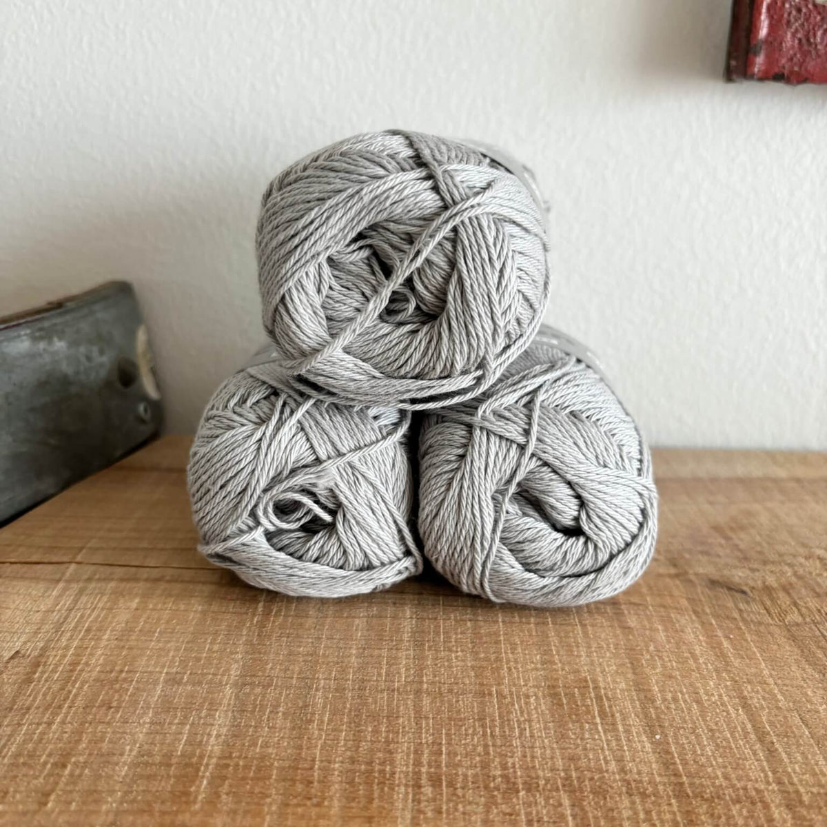 Tre garnnøgler Lammy Cotton 8/4 i lysegrå, stablet