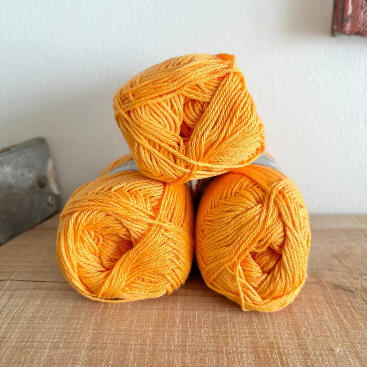 Tre garnnøgler Lammy Cotton 8/4 i orange, stablet