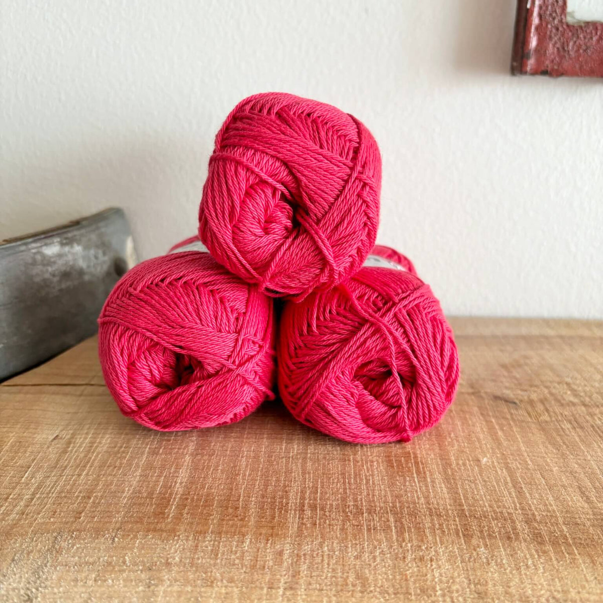 Tre garnnøgler Lammy Cotton 8/4 i rødt, stablet
