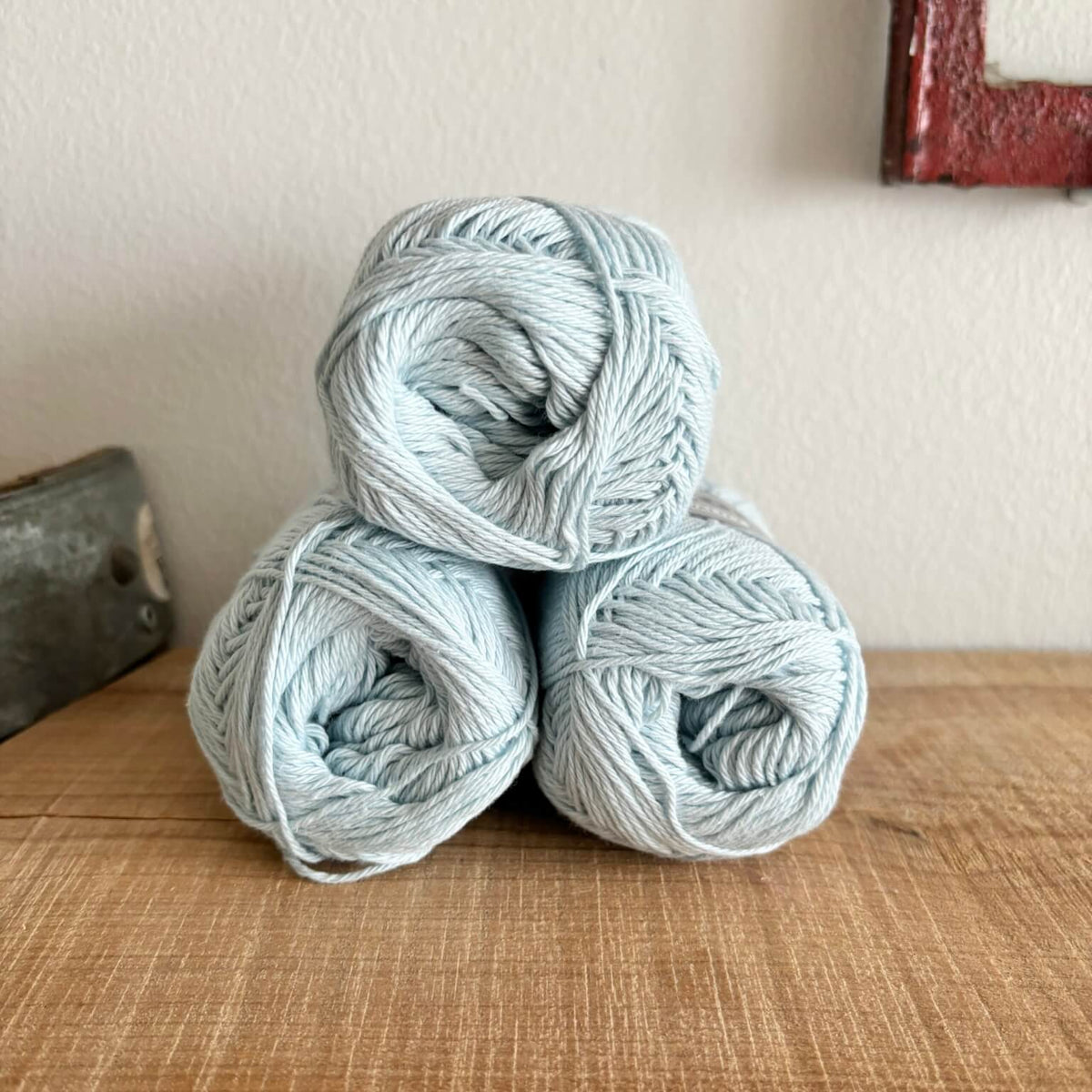 Tre garnnøgler Lammy Cotton 8/4 i lyseblå, stablet