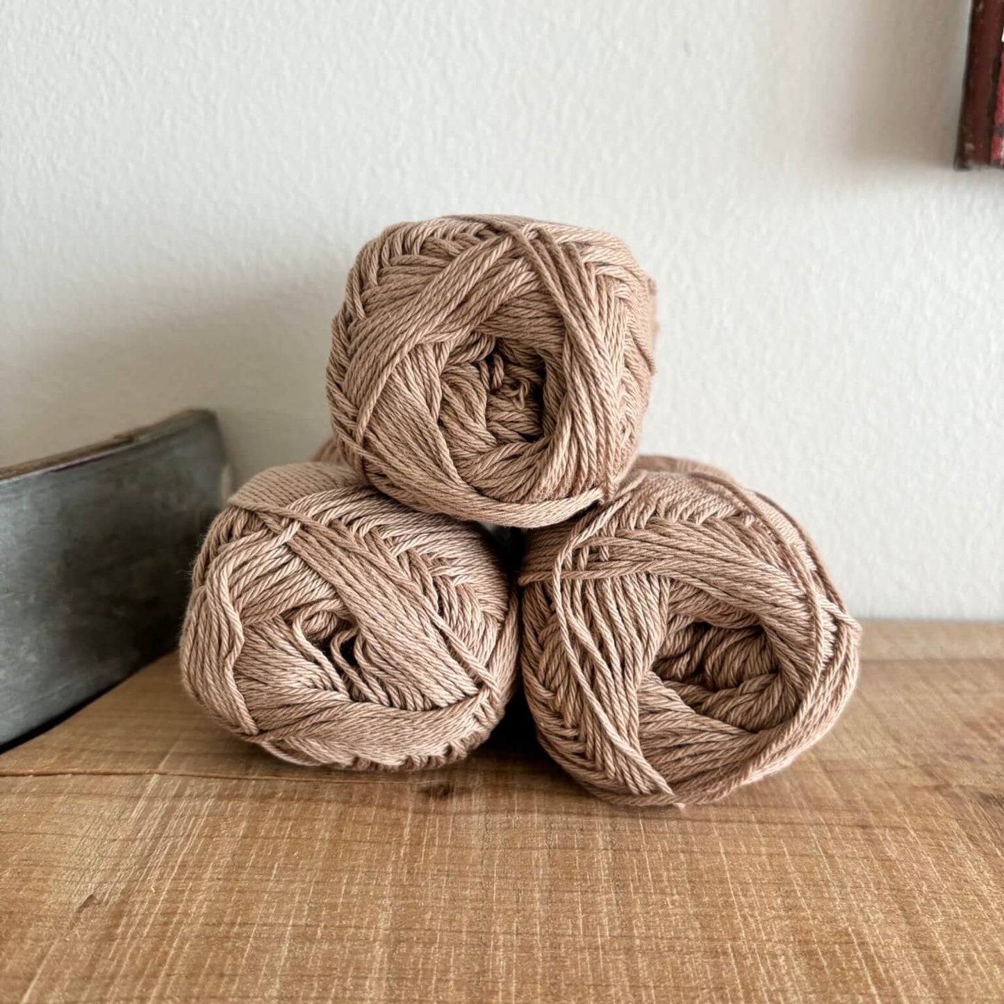 Tre garnnøgler Lammy Cotton 8/4 i lysebrun, stablet