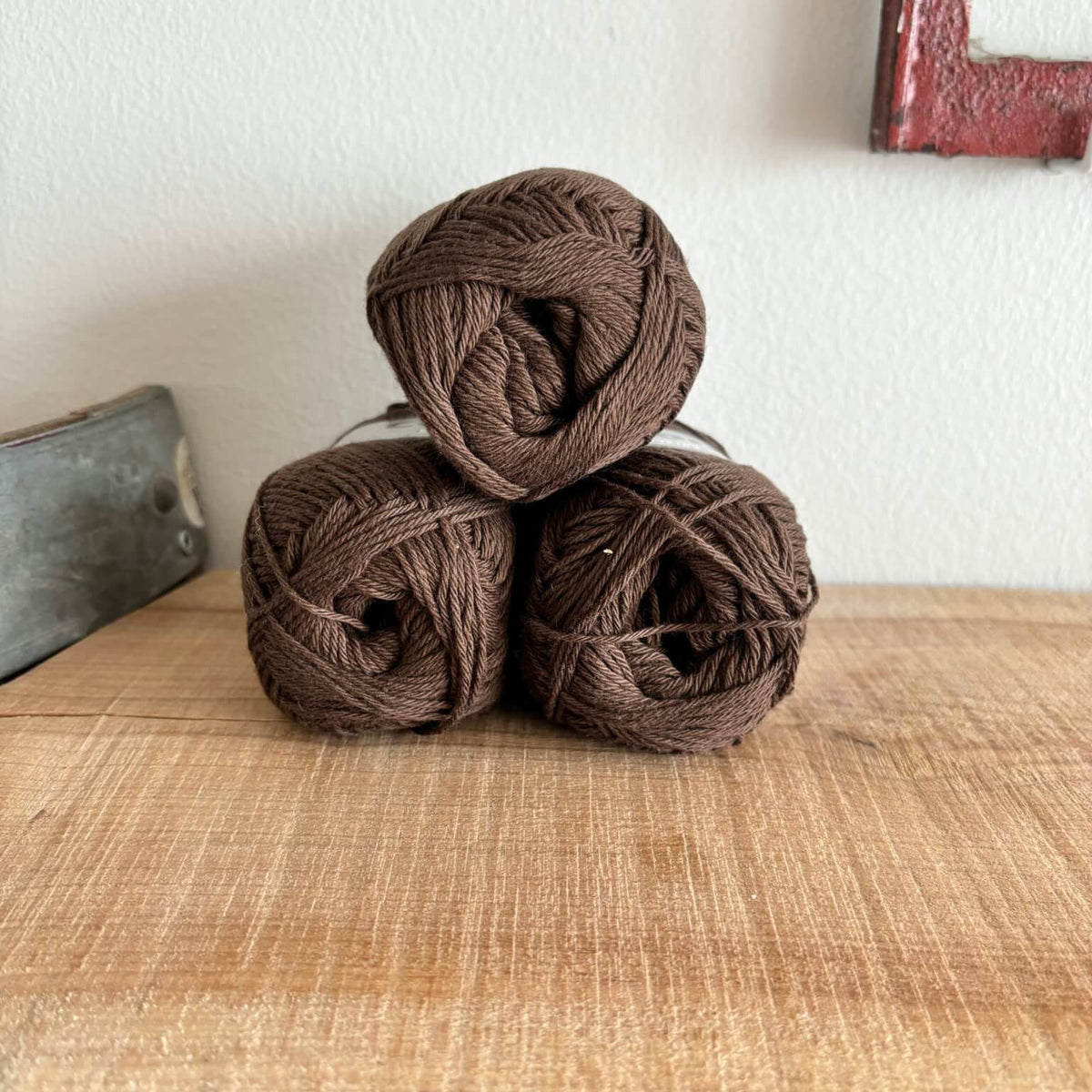 Tre garnnøgler Lammy Cotton 8/4 i mørk brun, stablet