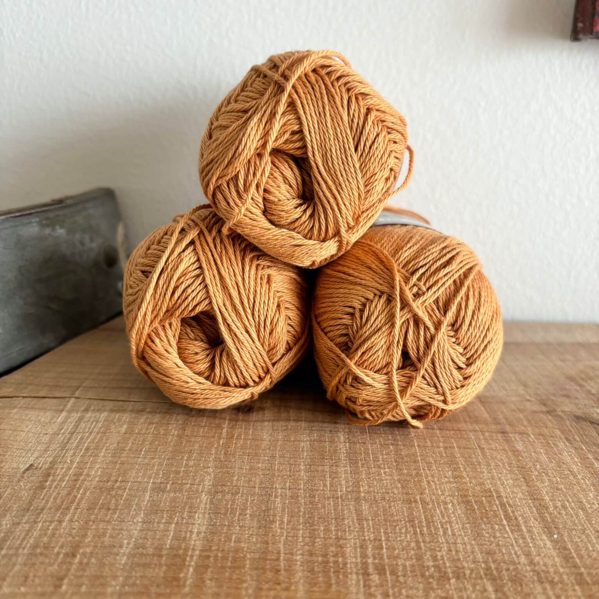 Tre garnnøgler Lammy Cotton 8/4 i karamelbrun, stablet