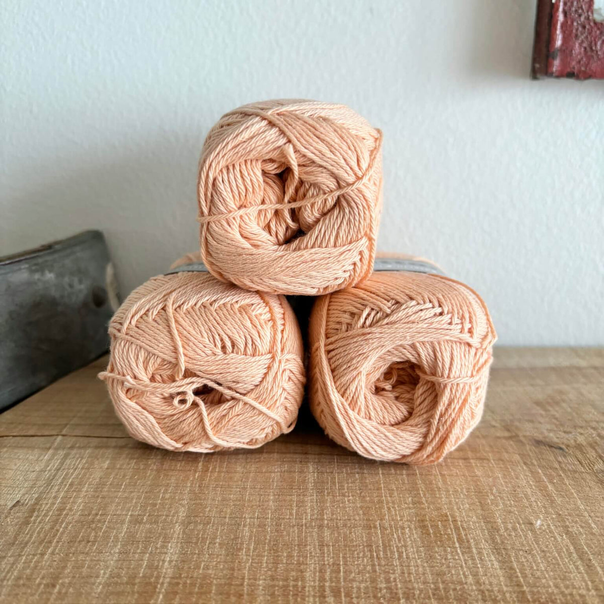Tre garnnøgler Lammy Cotton 8/4 i fersken, stablet