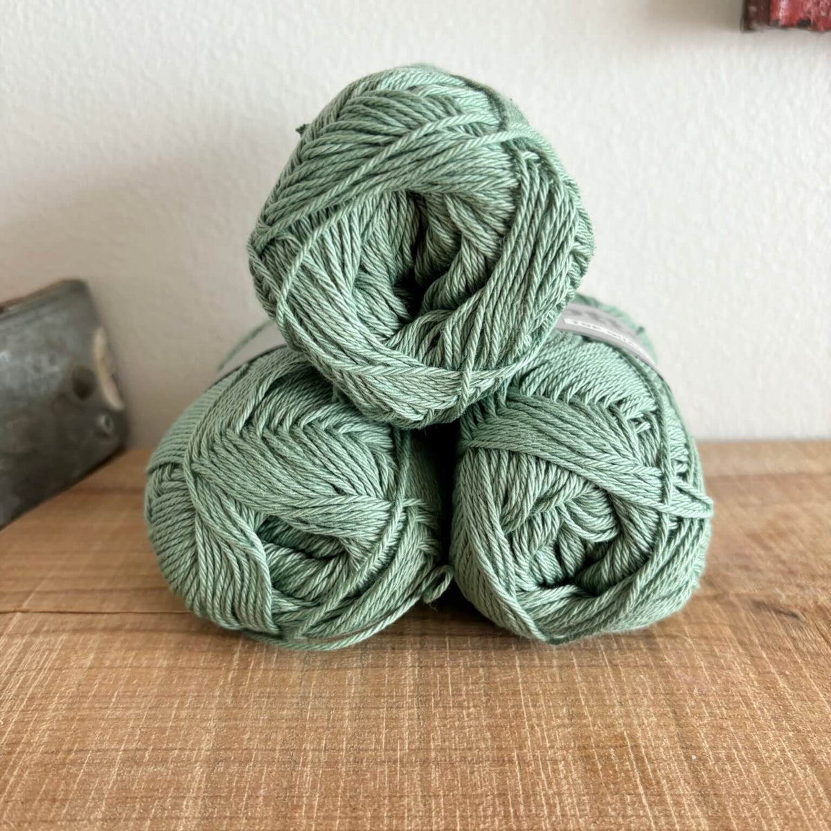 Tre garnnøgler Lammy Cotton 8/4 i laurbærbladgrøn, stablet