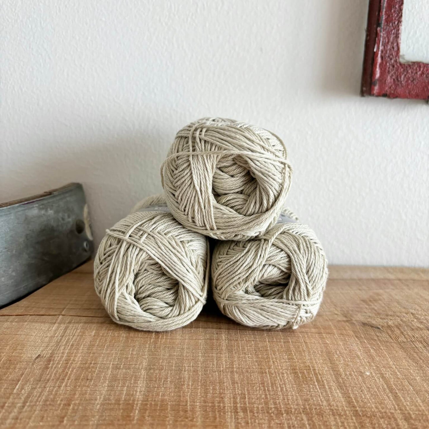 Tre garnnøgler Lammy Cotton 8/4 i beige, stablet