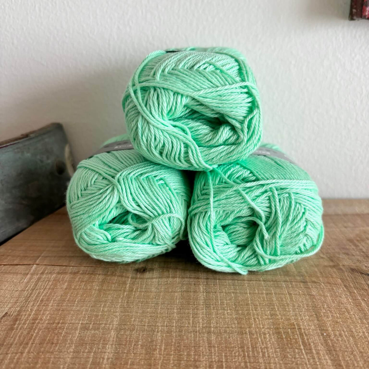 Tre garnnøgler Lammy Cotton 8/4 i mintgrøn med etiket, stablet