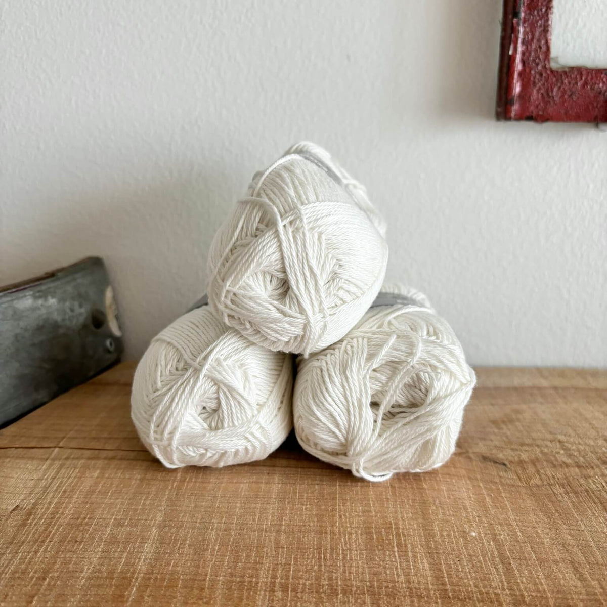 Tre garnnøgler Lammy Cotton 8/4 i råhvid, stablet