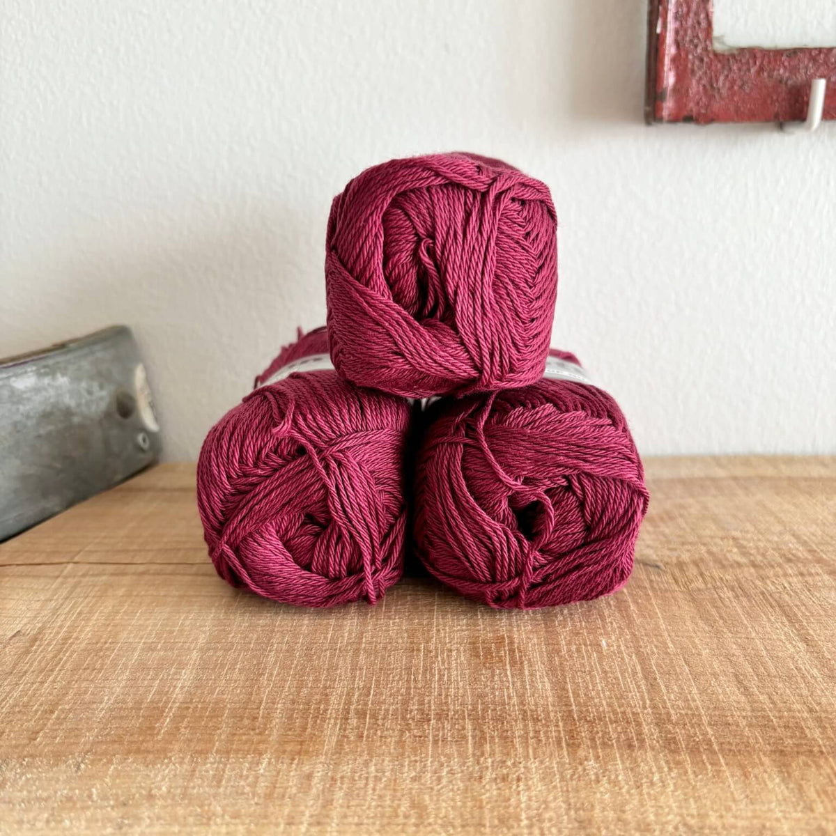 Tre garnnøgler Lammy Cotton 8/4 i vinrød, stablet