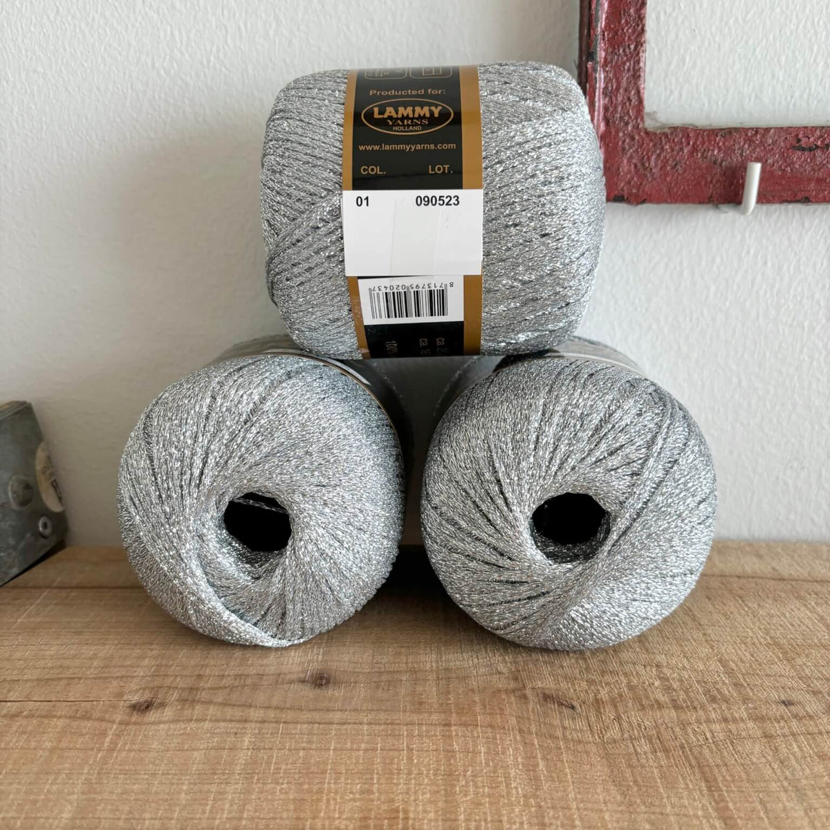 Tre garnnøgler Lurex glimmergarn i sølv nr. 1, stablet