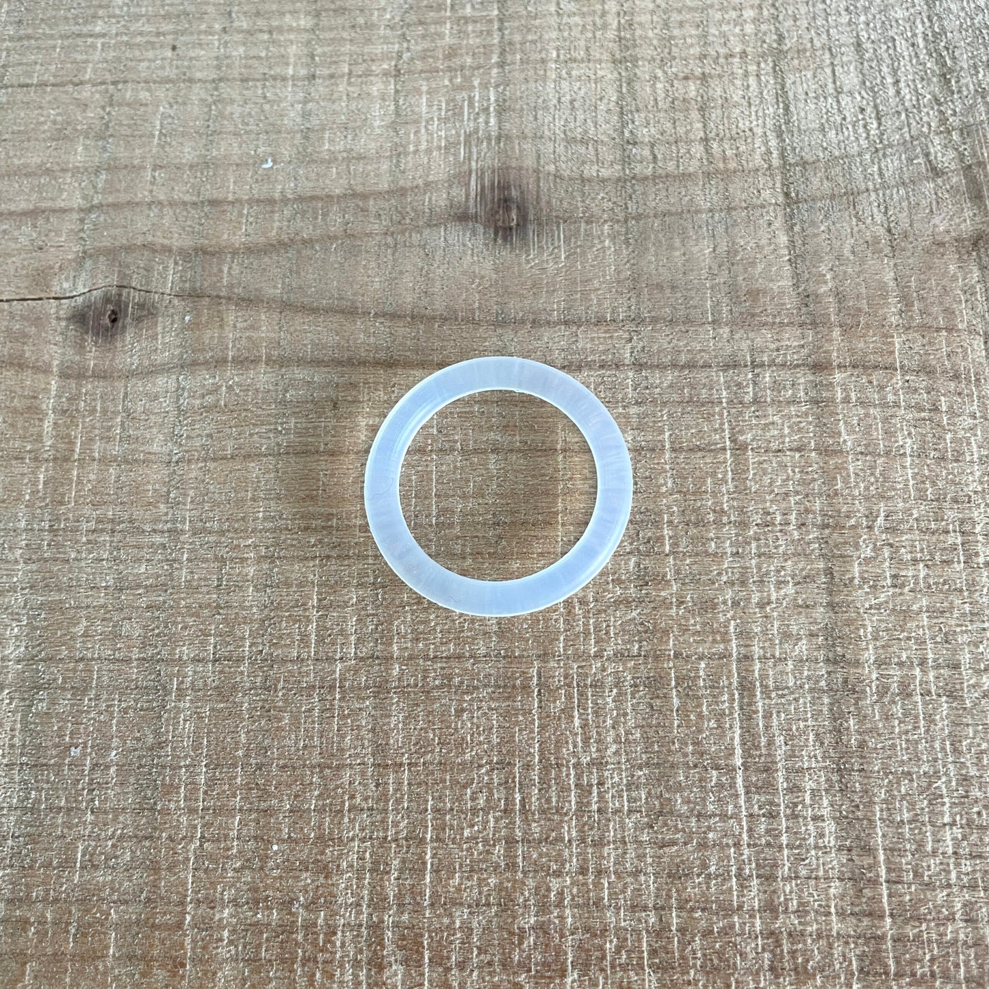 Transparent O-ring, nærbillede liggende på træbord