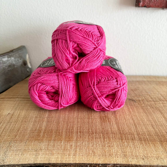 Bomuld 8/4 Oeko-Tex pink, nærbillede af tre garnnøgler