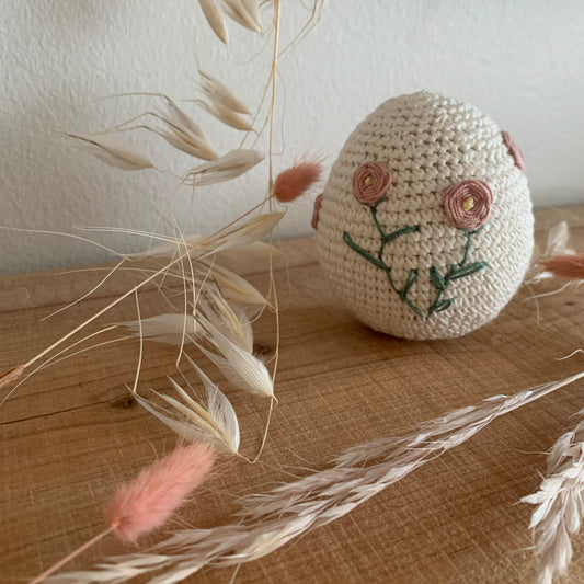 Hæklet påskeæg-tumling med roser placeret mellem tørrede blomster