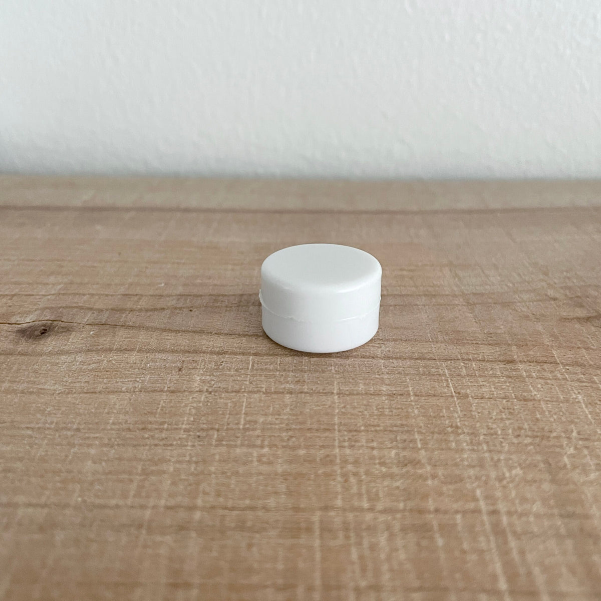 Hvid rasle på 21 mm i plast, nærbillede på bord