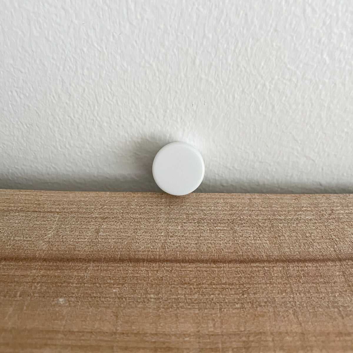 Hvid rasle på 21 mm i plast, nærbillede ved væg