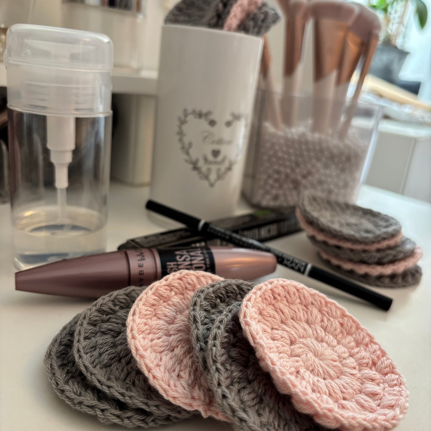 Rondeller i gråt og lyserødt ved makeupprodukter på bord