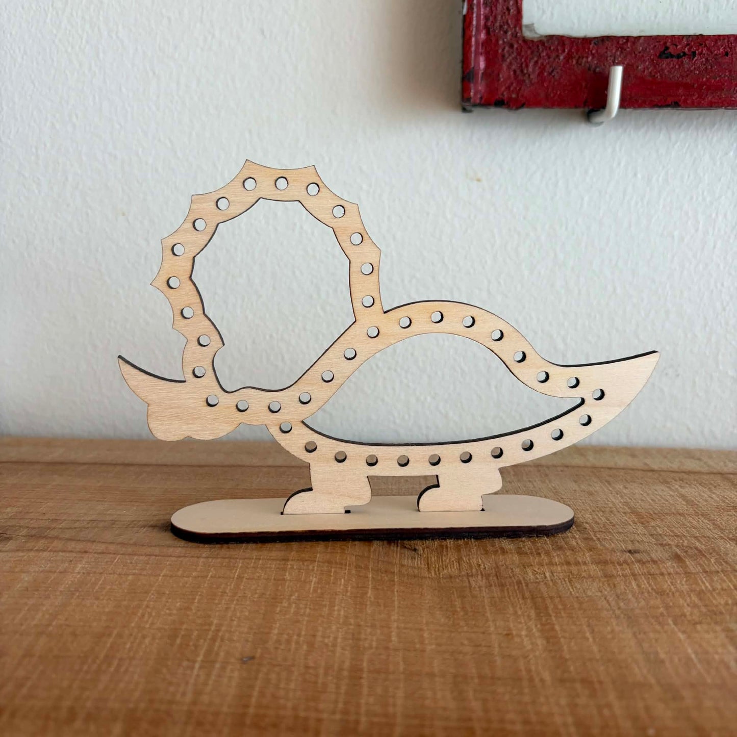 Træfigur af triceratops dinosaur i træ til broderi med garn, står på fod – Høvisch Design
